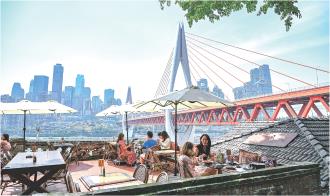 　　2025年5月1日，游客在重庆市南岸区龙门浩老街一餐厅用餐。
　　重庆是长江上游生态屏障的最后一道关口。近年来，重庆勇担上游责任，坚持把保护修复长江生态环境摆在压倒性位置，重拳治污换回碧水蓝天，强化修复实现美景常驻，有效发挥沿江岸线生态廊道功能，并依托生态修复成果，打造出众多文旅新场景、新地标，有效激发文旅融合新活力，提升群众幸福感、获得感和生活品质。
　　                      新华社记者 王全超 摄