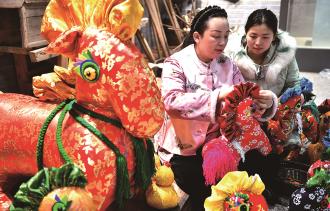 　　1月22日，河南驻马店市非遗香包制作技艺传承人王彩红（左）赶制新春特色香包。
　　春节临近，年味渐浓。各地举办年货大集、写福字春联等活动，人们选购鲜花、中国结等饰物，迎接新春。
　　
 新华社发
 （弓华静 摄）