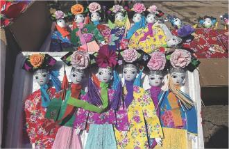 随着“燎疳节”的来临,华亭市山寨乡的集市早已按捺不住那份热烈。五颜六色的“疳娃娃”早已整整齐齐上了架,让过往的乡亲们一脚踏进这烟火气里,赶一场流传千年的民俗大集,把家乡的温情和年味,一并装进心里。
“疳娃娃”,这小小的纸偶,是人们对“疳”字的温柔化解——过去是祈求孩子无病无灾、平安长大,如今,它已悄悄“长大成人”,承载起姻缘顺遂、家族兴旺的期盼。那些摆在摊上的疳娃娃,竹棍为骨,彩纸作衣,鸡蛋壳画成脑袋,眉眼弯弯、神气活现。给男娃挑的“疳媳妇”,柳眉杏眼、巧笑嫣然;给女娃选的“疳女婿”,浓眉大眼、一身正气。每一个,都是匠人用心捏出来的祝福。小小的“疳娃娃”,从驱邪避病的符号,变成今天人们对美好生活的朴素表达。
本报记者 李洁 摄影报道